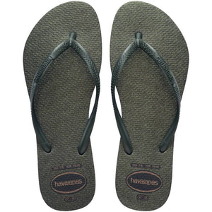 Pair of green glitter flip flops with Havaianas logo on a white background