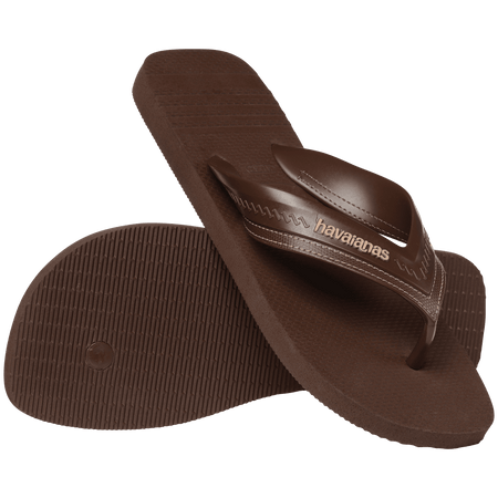 dark brown sandals with rice pattern and grooves, with brown straos with a lighter brown stitched-look detailing, one shoe leaning on the other toe side down