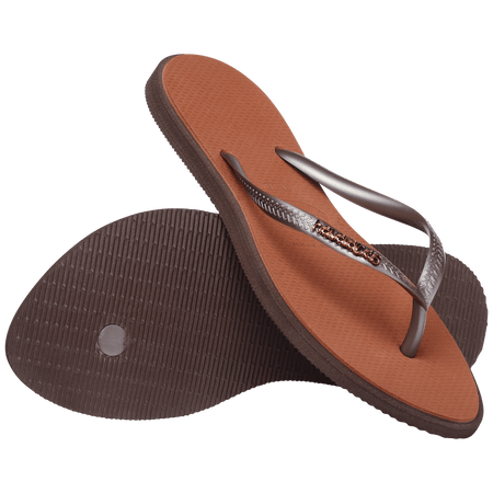 brown sandals with a dark brown outline around the footbed and metallic brown straps with a metal brown havaianas logo, one shoe leaning on the other toe side down