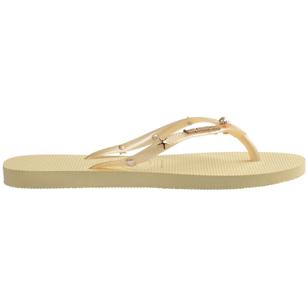 light yellow/buttercream sandals with yellow straps and crystals and pearls and star charms adorning the straps, side view