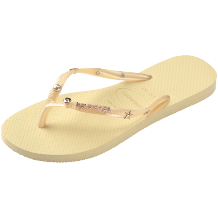 light yellow/buttercream sandals with yellow straps and crystals and pearls and star charms adorning the straps, front left view