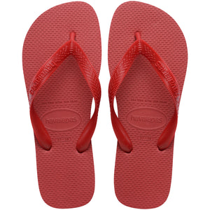 Pair of red Havaianas flip flops on a white background