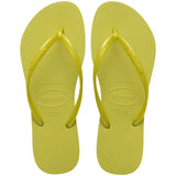 Pair of lime green flip flops with Havaianas branding on a white background