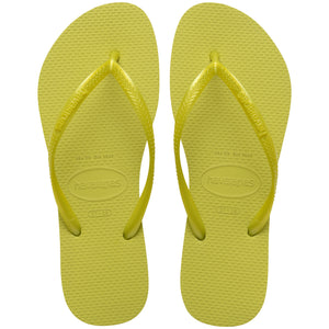 Pair of lime green flip flops with Havaianas branding on a white background