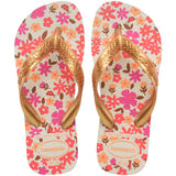 Floral patterned Havaianas flip flops with gold straps on a white background