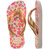 Floral patterned Havaianas flip flops with gold straps on a white background, with left shoe in focus