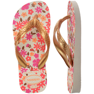 Floral patterned Havaianas flip flops with gold straps on a white background, with left shoe in focus