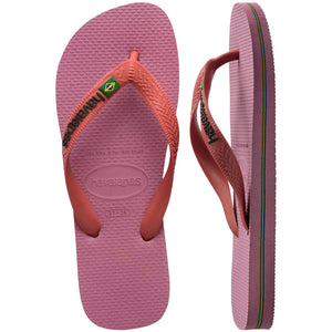 Pair of pink Havaianas flip flops with the thicker top strap, left shoe in focus, on a white background