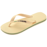 light yellow flip flops with yellow straps that say havaianas in brown, and a brazil flag, front left view