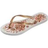 Left, single Havaianas flip flop with floral design and gold straps on a white background