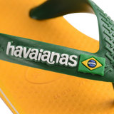 yellow flip flops with green heel straps featuring a brazil flag,zooming in on strap and white havaianas written on the strap with a brazil flag next to it