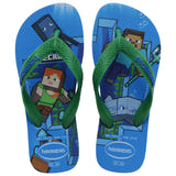 Pair of kids' Havaianas Minecraft flip-flops with green straps and a blue footbed. The design features Steve and Alex from Minecraft alongside pixelated underwater elements, aquatic creatures, and block-style graphics. The Havaianas logo appears on the straps and near the heel.
