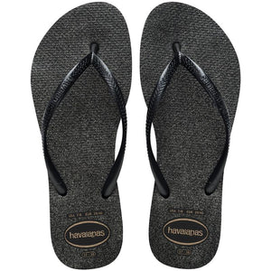 Pair of black glitter flip-flops with Havaianas logo on a white background