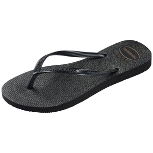 single, left side Havaianas black flip-flop with a textured, glitter sole on a white background on a white background