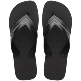 black sandals with rice patterned grooves and striped grooves on the footbed, with black straps and a grey stitched like pattern, top view