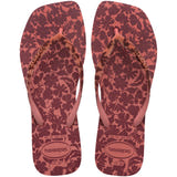 Flip-flops featuring a brown and pink floral print and matching patterned straps, top view
