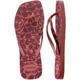 Flip-flops featuring a brown and pink floral print and matching patterned straps, one shoe top view one shoe side view