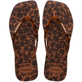 Flip-flops featuring a brown and black floral print and matching patterned straps, top view