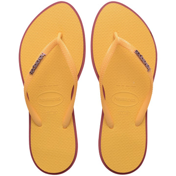 Pair of yellow Havaianas flip flops with red accents on a white background