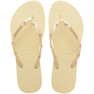 light yellow/buttercream sandals with yellow straps and crystals and pearls and star charms adorning the straps, top view