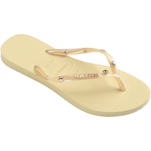light yellow/buttercream sandals with yellow straps and crystals and pearls and star charms adorning the straps, front right view