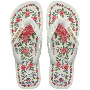 flip flops with pink flowers on a white background with white straps with a gold havaianas logo on them, top facing