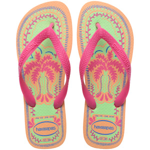 Pair of Havaianas flip flops with pink straps and colorful palm tree design on a white background