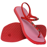 Top and side view of sandal with red back straps, silver studs, and pink sole