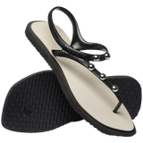 Angled view of sandal with black back straps, silver studs, and white sole
