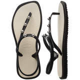 Top and side view of sandal with black back straps, silver studs, and white sole