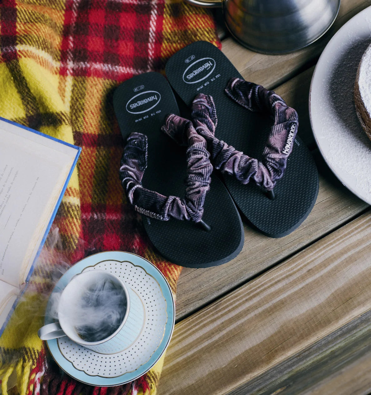 Pair of Havaianas flip flops with fluffy fabric straps on a Fall themed table.
